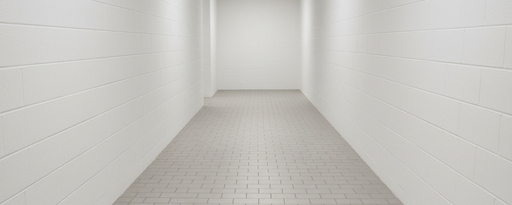 Bright white industrial hallway with new light gray tile flooring.